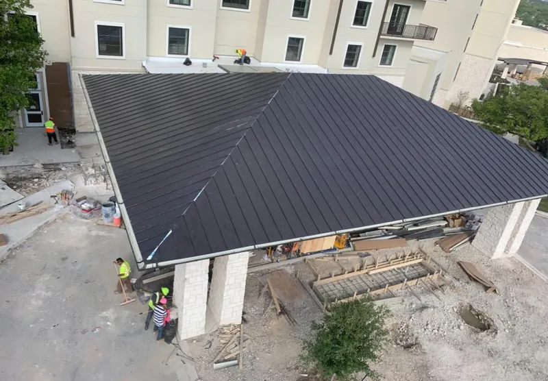 Metal roofing installation team working on a commercial building in Bloomington